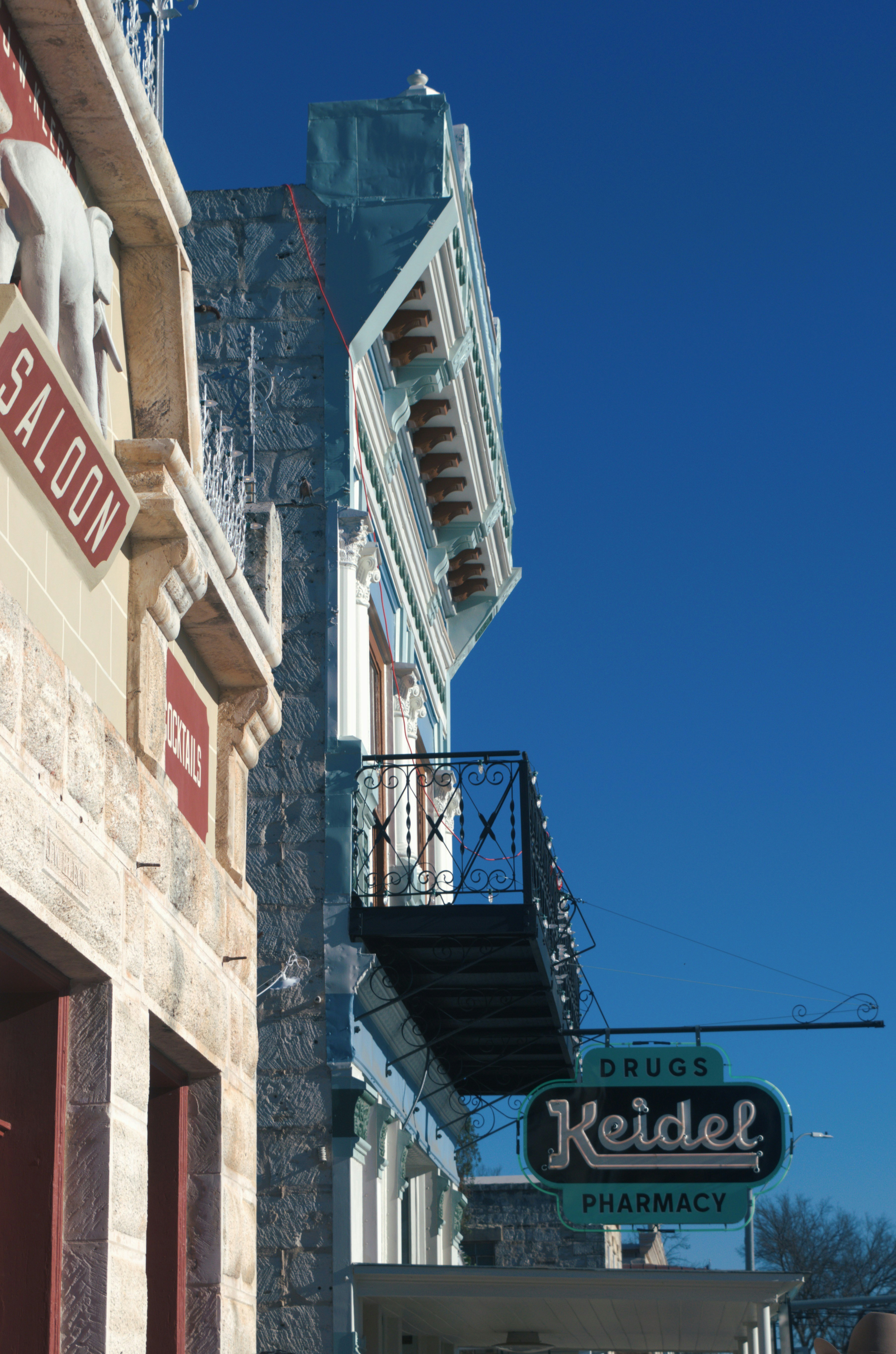 Historic Main Street buildings in Fredericksburg, Texas, with the vintage Keidel Pharmacy neon sign