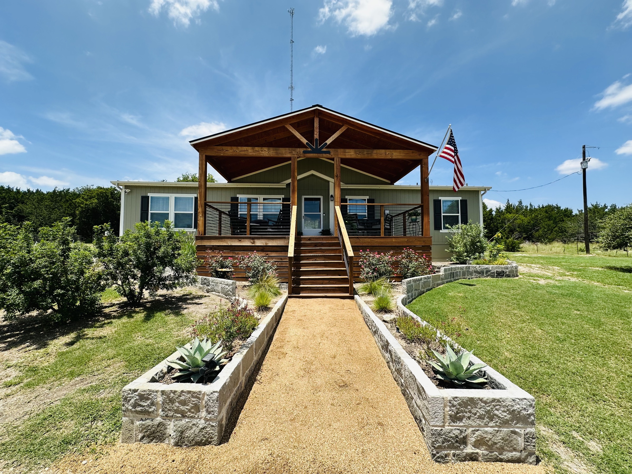 Front walkway lined with agave planters leading to the covered porch